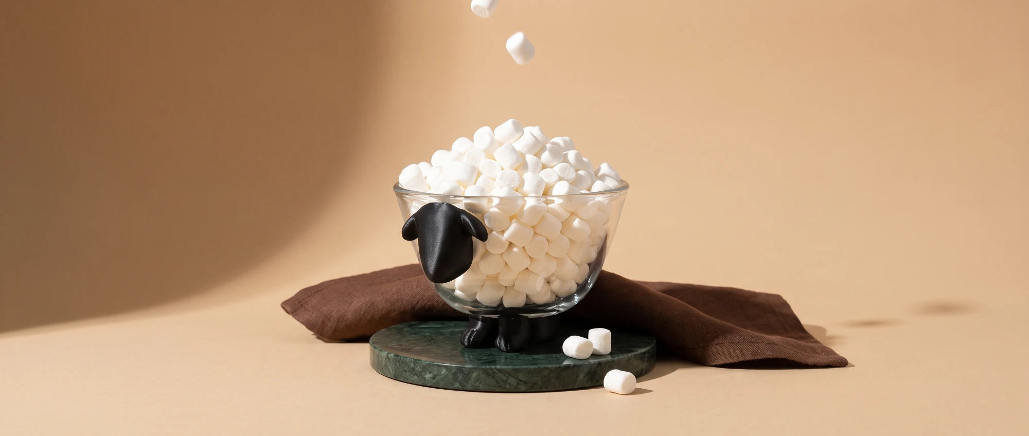 Sheeply sheep glass bowl filled with mini marshmallows on a green marble coaster